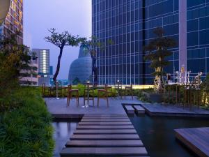 a patio with tables and chairs in a city at JHL Solitaire Gading Serpong in Serpong
