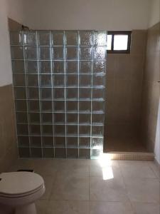 y baño con aseo y ducha de azulejos. en Jardin El Rompio Casa 35, en Los Santos