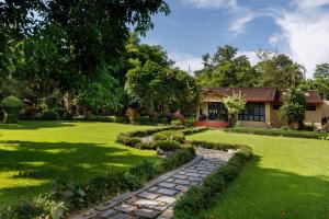 a garden with a stone path leading to a house at Green Mansions Jungle Resort in Sauraha