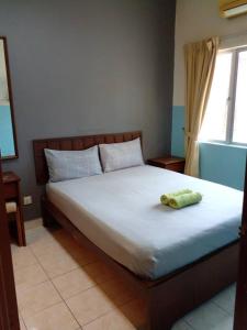 Kampong SelematにあるBukit Merah 99 Motel(Suria Apartment)のベッドルーム1室(タオル付きのベッド1台付)