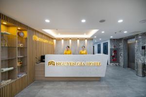 two people standing at a reception desk in a building at Nguyen Gia Hotel in Danang