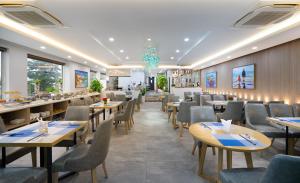 Nguyen Gia Hotel في دا نانغ: مطعم بطاولات وكراسي وثريا