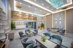 Nguyen Gia Hotel في دا نانغ: لوبي فندق فيه كراسي وطاولات
