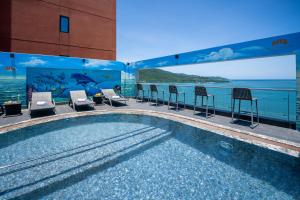 a swimming pool with chairs and a view of the ocean at Nguyen Gia Hotel in Da Nang