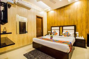 a bedroom with a large bed with wooden walls at FabHotel Jannat Zirakpur in Zirakpur