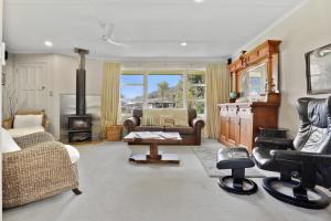 a living room with leather furniture and a fireplace at Pukeko Lodge - Tūrangi Holiday Home in Turangi