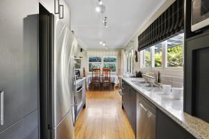 a kitchen with stainless steel appliances and a dining room at Pukeko Lodge - Tūrangi Holiday Home in Turangi