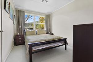 a bedroom with a bed and a window at Pukeko Lodge - Tūrangi Holiday Home in Turangi