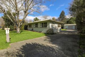 a house with a driveway in front of it at Pukeko Lodge - Tūrangi Holiday Home in Turangi