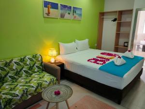 um quarto de hotel com uma cama e um sofá em Nadi Fancy Hotel em Nadi