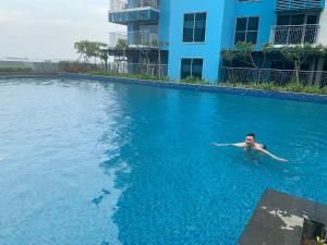 Ein Mann schwimmt im Pool in der Unterkunft Le Maisse Executive Studio 1BR opp Okada in Manila