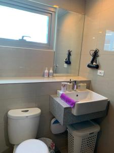 a bathroom with a sink and a toilet and a window at Le Maisse Executive Studio 1BR opp Okada in Manila
