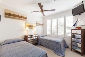 - une chambre avec 2 lits et un ventilateur de plafond dans l'établissement 12 60 Peregian Esplanade Peregian Beach, à Peregian Beach