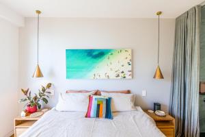 a bedroom with a bed and a painting on the wall at Spectacular Bilgola Beachhouse in Avalon