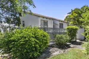 ein weißes Haus mit einem Zaun und einigen Büschen in der Unterkunft 3 2 Katharina Street Noosa Heads in Noosa Heads