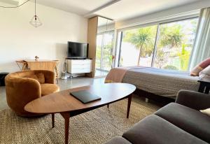 a hotel room with a bed and a couch and a table at Scandi Beach apartment in Avalon