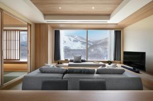 a living room with a couch and a large window at Setsu Niseko in Niseko