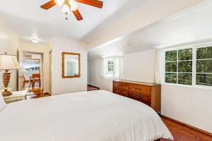 a white bedroom with a large bed and a window at Summit House in Guerneville