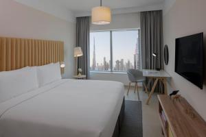 a hotel room with a large bed and a large window at Staybridge Suites Dubai Financial Centre, an IHG Hotel in Dubai