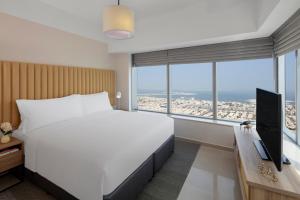 a bedroom with a large white bed and a large window at Staybridge Suites Dubai Financial Centre, an IHG Hotel in Dubai