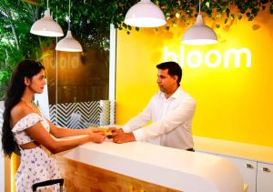 un hombre y una mujer estrechando la mano sobre un mostrador en Bloom Hotel - Gachibowli en Hyderabad