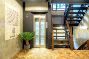 a hallway with a staircase and a potted plant at OYO 75456 Episode 11 Hostel Sukhumvit in Bangkok