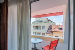 a room with a window with a table and a chair at Hotel Tranzzit in Bucharest