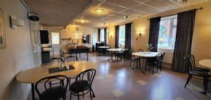 a restaurant with tables and chairs in a room at Nipanhotellet in Sollefteå