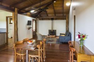 a dining room and living room with a table and chairs at Rose Gums Wilderness Retreat in Butchers Creek