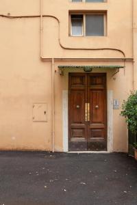 un edificio con una puerta de madera delante de él en Il Melograno Holiday House, en Roma