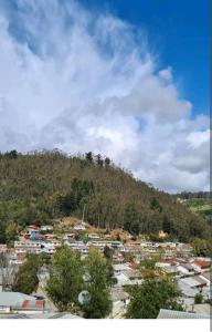 una ciudad en la cima de una colina con una montaña en EL GRAN ROBLE. en Constitución