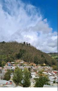 a town on top of a hill with a mountain at EL GRAN ROBLE. in Constitución
