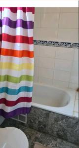 baño con cortina de ducha colorida y bañera en EL GRAN ROBLE. en Constitución