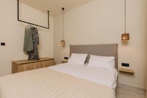 a bedroom with a large white bed with two pillows at Olvion Suites in Skala Sotiros