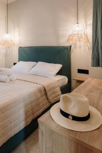 a bedroom with two beds and a hat on a table at Olvion Suites in Skala Sotiros