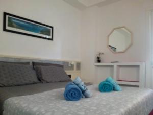 チェファルにあるCasa Sandraのベッドルーム(青い枕と鏡付きのベッド1台付)