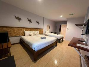 ein Hotelzimmer mit 2 Betten und einem TV in der Unterkunft Thebedkolok resort in Sungai Kolok