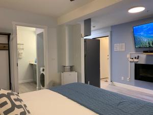 een slaapkamer met een bed en een tv aan de muur bij A Romantic Studio with Full Kitchen & AC-141 in Canmore