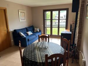 a living room with a table and a blue couch at Apartamento a pie de pistas de Espot ZZ House in Espot