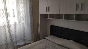een slaapkamer met een bed en een raam met gordijnen bij La culla di Giove in Terracina