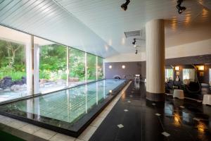 a swimming pool in a house with glass walls at Otaru Asari Classe Hotel in Otaru