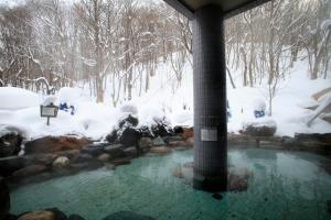 een hot tub in een met sneeuw bedekte tuin bij Otaru Asari Classe Hotel in Otaru
