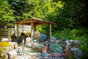 a small swimming pool with rocks and a wooden structure at Otaru Asari Classe Hotel in Otaru