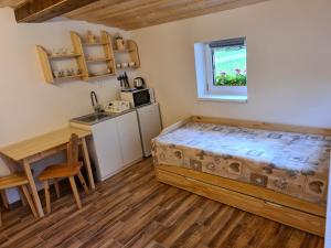 a bedroom with a bed and a table and a kitchen at Chata u Petrenkov in Horná Turecká