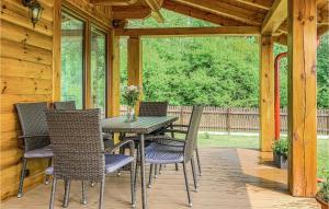 a wooden patio with a table and chairs on a porch at 4 Bedroom Amazing Home In Ruciane-nida in Karwica