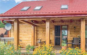 a wooden cabin with a red roof and a patio at 4 Bedroom Amazing Home In Ruciane-nida in Karwica