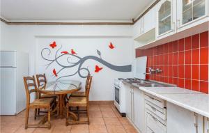 a kitchen with a table and a tree with birds on it at Gorgeous Apartment In Njivice With Kitchen in Njivice