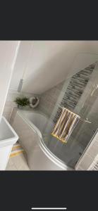 2 Bedroom duplex apartment في بوتري: حوض استحمام أبيض في حمام مع أرضية من البلاط