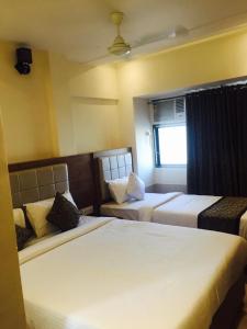 a hotel room with two beds and a couch at Hotel Sea View - Near Taj Hotel in Mumbai