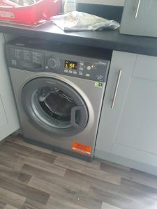 a washing machine is sitting in a kitchen at Immaculate 7 Bed House in Ashton-under-Lyne OL7 in Manchester